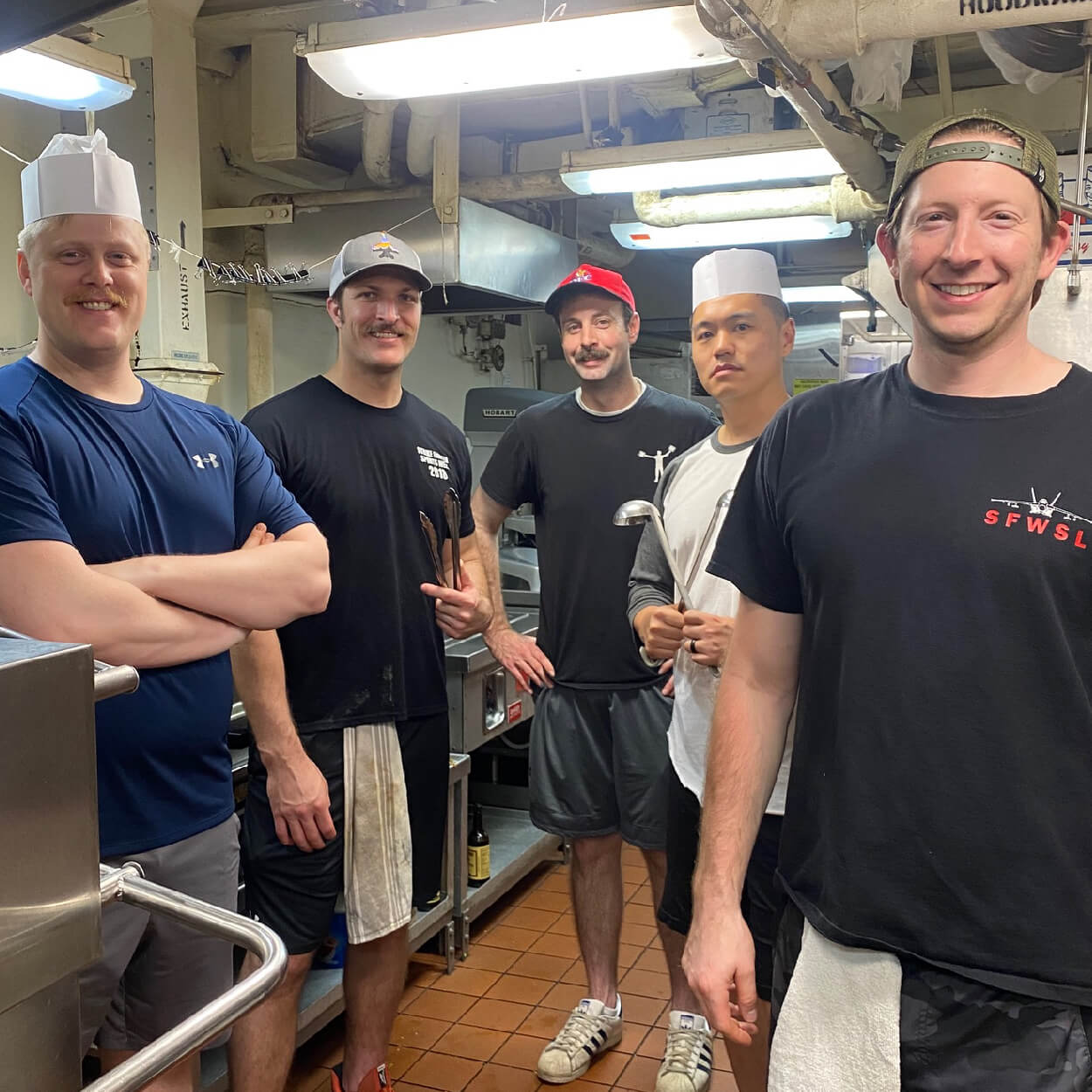 Hangar Bay Spice founder, BIFF and friends in a kitchen cooking on deployment